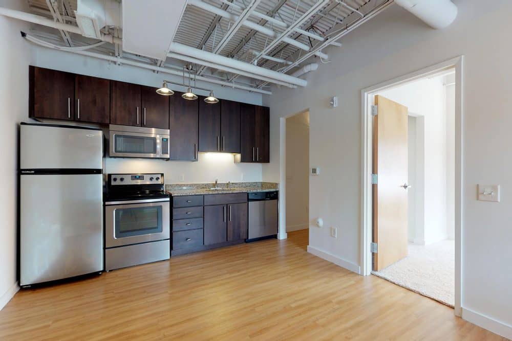 courtyard lofts unit 423 kitchen faux wood flooring stainless steel appliances exposed ceiling beams